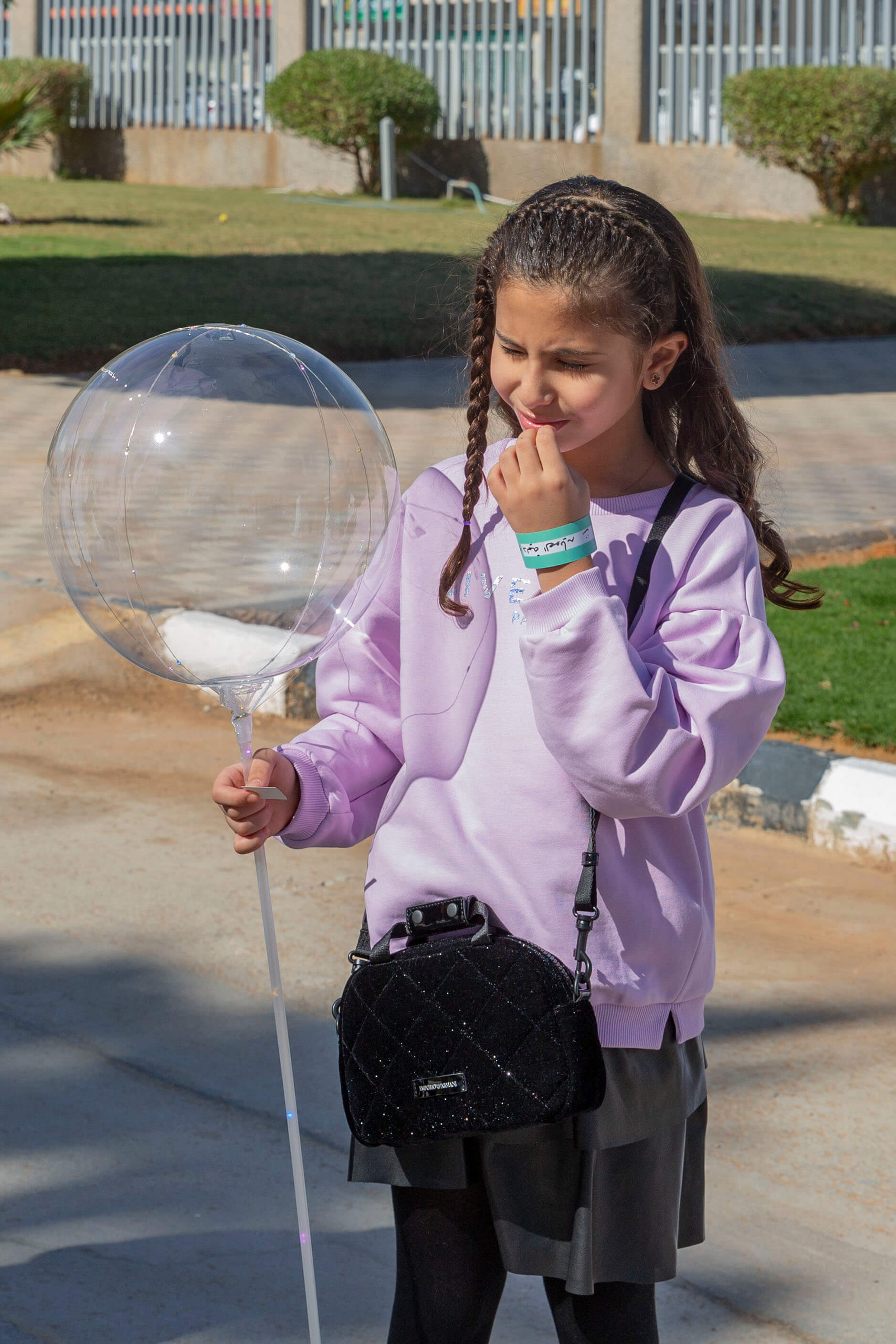  طفلة تفكر ممسكة بيدها اليمنى نفاخة شفافة